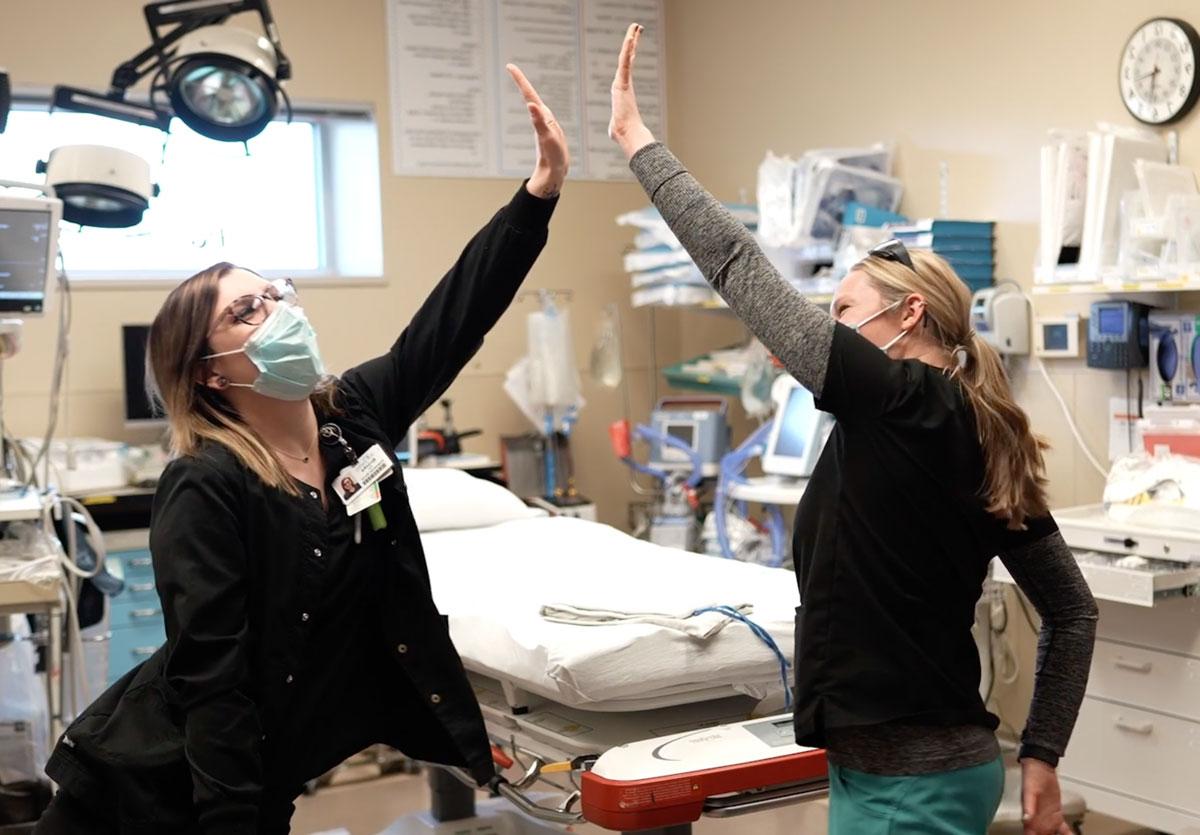两个澳门皇冠app官网手机版app下载 caregivers air high-fiving in a patient room